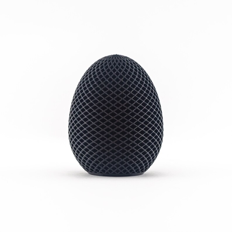 May include: A black egg-shaped object with a geometric pattern.
