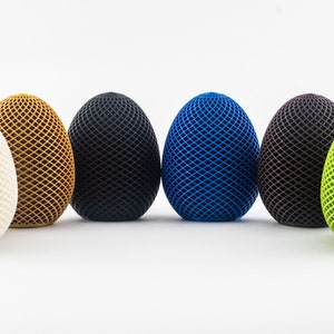 May include: Six decorative eggs with a geometric pattern. The eggs are white, brown, black, blue, brown, and green.