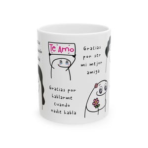 Op de afbeelding: Witte keramische mok met cartoonfiguren en Spaanse tekst. Een figuur houdt een bord met de tekst "Te Amo". Andere tekst is "Gracias por ser mi mejor amiga" en "Gracias por hablarme cuando nadie habla."