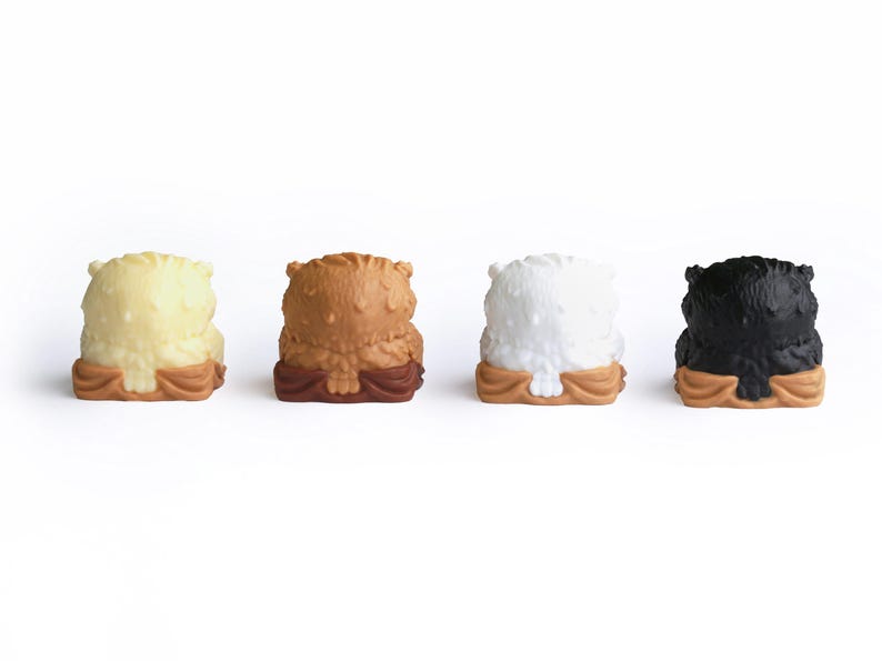 Puede incluir: Cuatro peque&ntilde;as figuras de b&uacute;ho en fila. Los b&uacute;hos son de color crema, marr&oacute;n, blanco y negro. Cada uno tiene un cuerpo texturizado y se asienta sobre una base marr&oacute;n. El fondo es blanco liso.