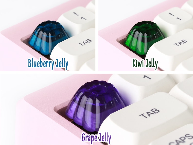 May include: Three jelly keycaps in different colors: blue, green, and purple. The keycaps are shaped like a jelly mold and are sitting on a white keyboard.