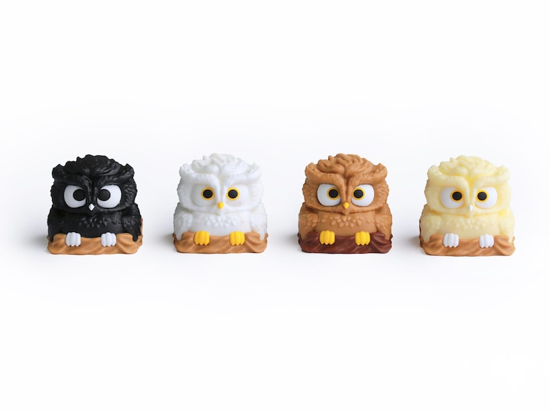 Puede incluir: Cuatro figuras de b&uacute;hos en negro, blanco, marr&oacute;n y amarillo. Cada b&uacute;ho tiene ojos grandes y est&aacute; posado en una rama marr&oacute;n. Los b&uacute;hos son peque&ntilde;os y decorativos, con un dise&ntilde;o de dibujos animados.
