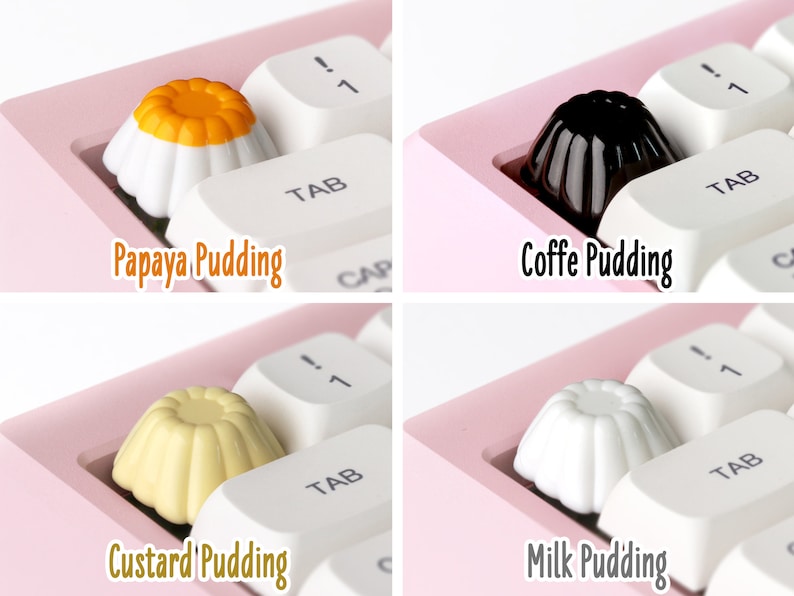 May include: Four different pudding-shaped keycaps for a keyboard. The keycaps are white, yellow, black, and orange. The keycaps are labeled "Papaya Pudding", "Coffe Pudding", "Custard Pudding", and "Milk Pudding".