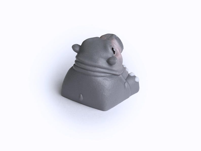 Puede incluir: Un keycap gris en forma de hipop&oacute;tamo con un acento blanco en la oreja. El keycap est&aacute; hecho de pl&aacute;stico liso y mate.