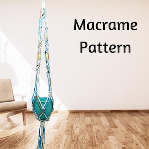 May include: Macrame plant hanger with a blue and white cord pattern. The hanger is holding a teal planter.