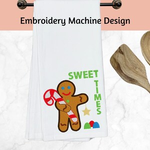 May include: White kitchen towel with an embroidered gingerbread man holding a candy cane and the text "Sweet Times".