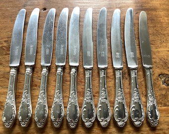 Coffret de 10 couteaux de table à manches en métal argenté.