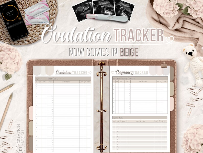 Peut inclure: Reliure de suivi de l'ovulation et de la grossesse beige et blanche avec un c&oelig;ur et le texte "Ovulation Tracker" et "Pregnancy Tracker".