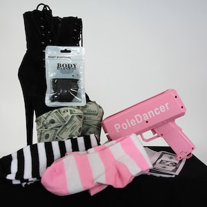 May include: A pink toy gun with the words "PoleDancer" printed on it, a pair of black and white striped socks, a pair of pink and white striped socks, a black boot with a dollar bill pattern, and a small package labeled "Body Harness".
