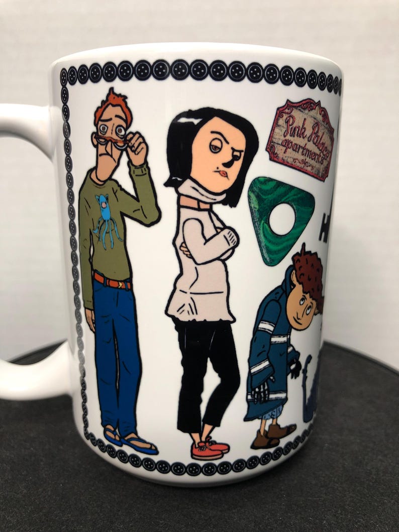 May include: White ceramic mug featuring cartoon illustrations of characters. The mug has a black button border and the words "Pink Palace Apartments" are visible. The characters are in various outfits and poses.