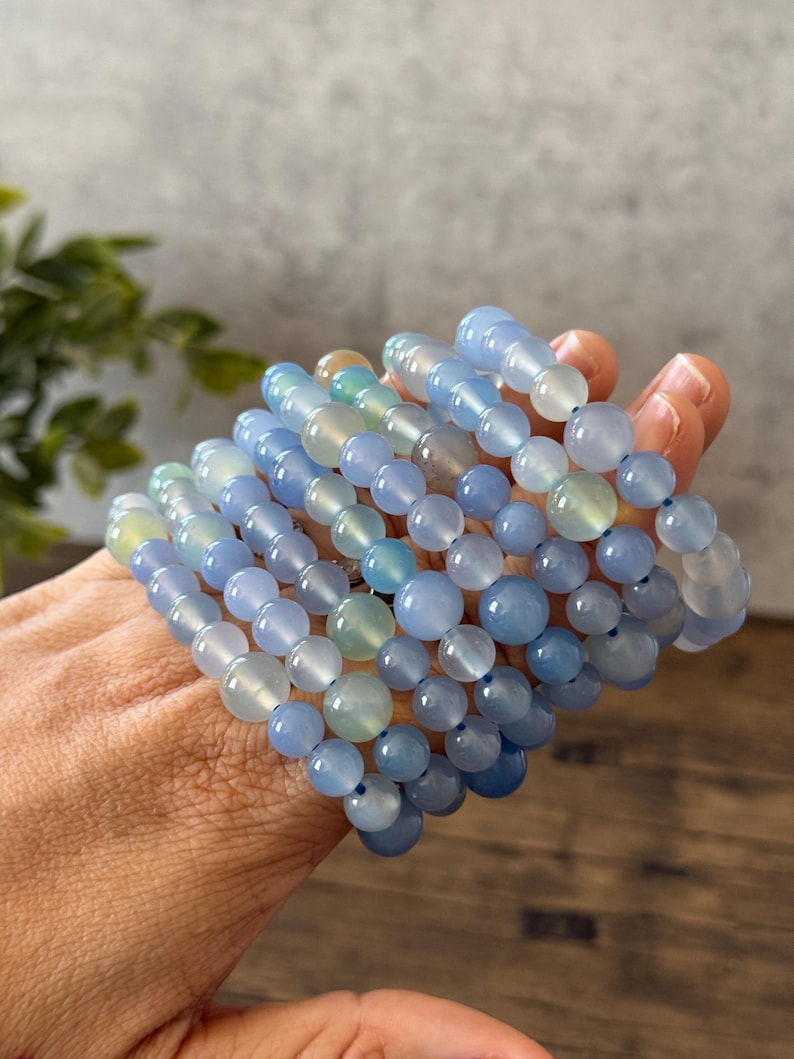 Puede incluir: Una pila de pulseras de piedras preciosas azules y verdes con cuentas redondas. Las pulseras est&aacute;n hechas de piedras naturales y son perfectas para superponer.