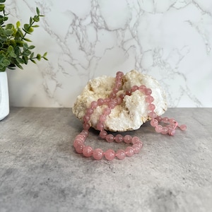 Rose Quartz Necklace made with 64 10mm, 6 12mm beads at the center with 2 additional 8mm beads at end of pull closure