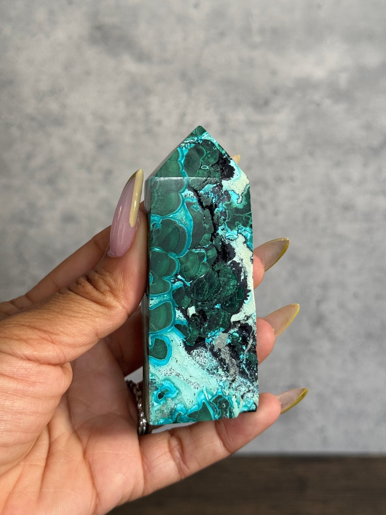Puede incluir: Una punta de cristal de azurita verde y azul con un patr&oacute;n de remolino. El cristal est&aacute; pulido y tiene una superficie lisa.