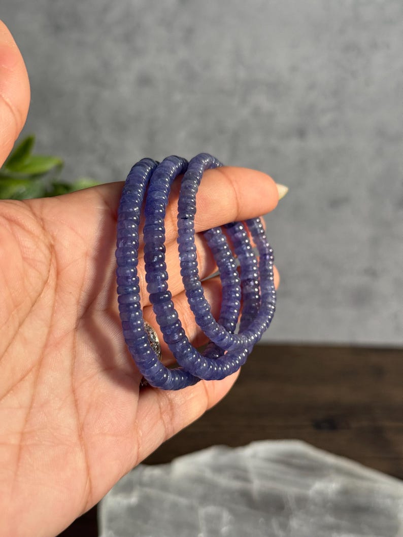 Puede incluir: Una pila de tres pulseras de piedras azules hechas de peque&ntilde;as cuentas redondas.