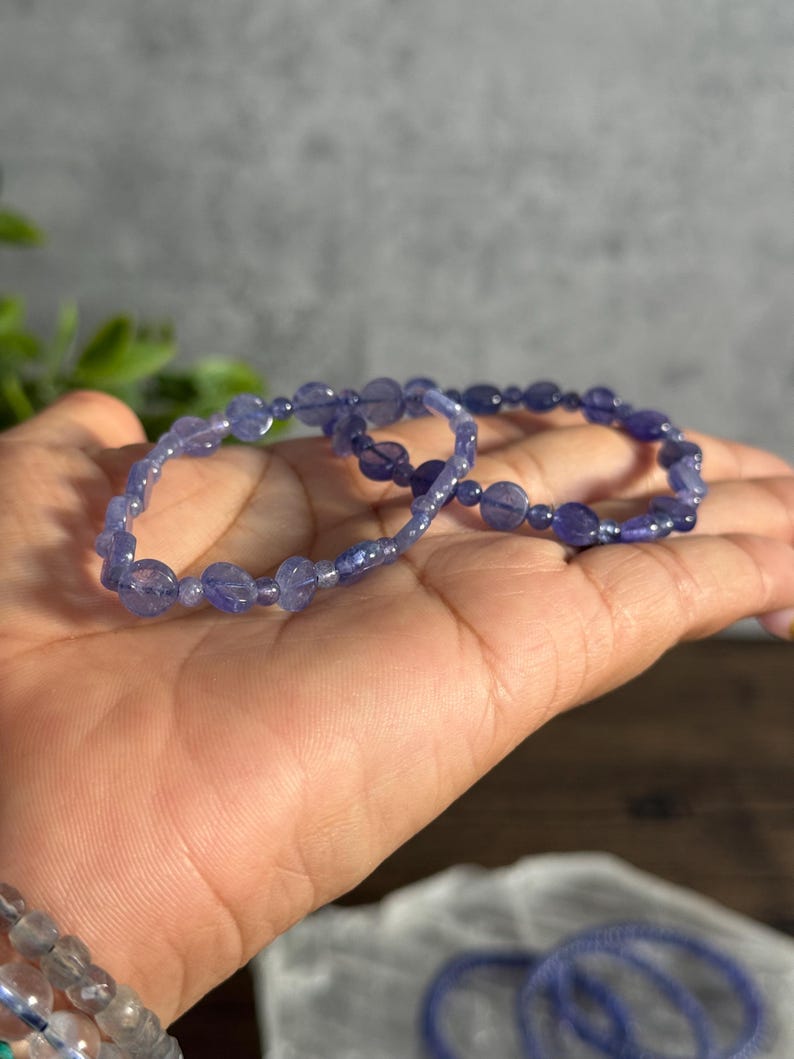 Puede incluir: Dos pulseras de piedras preciosas moradas con peque&ntilde;as cuentas redondas. Las pulseras est&aacute;n hechas de piedras naturales y est&aacute;n apiladas una encima de la otra.