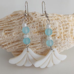 Seashell dangle earring with blue and white bead accents.
