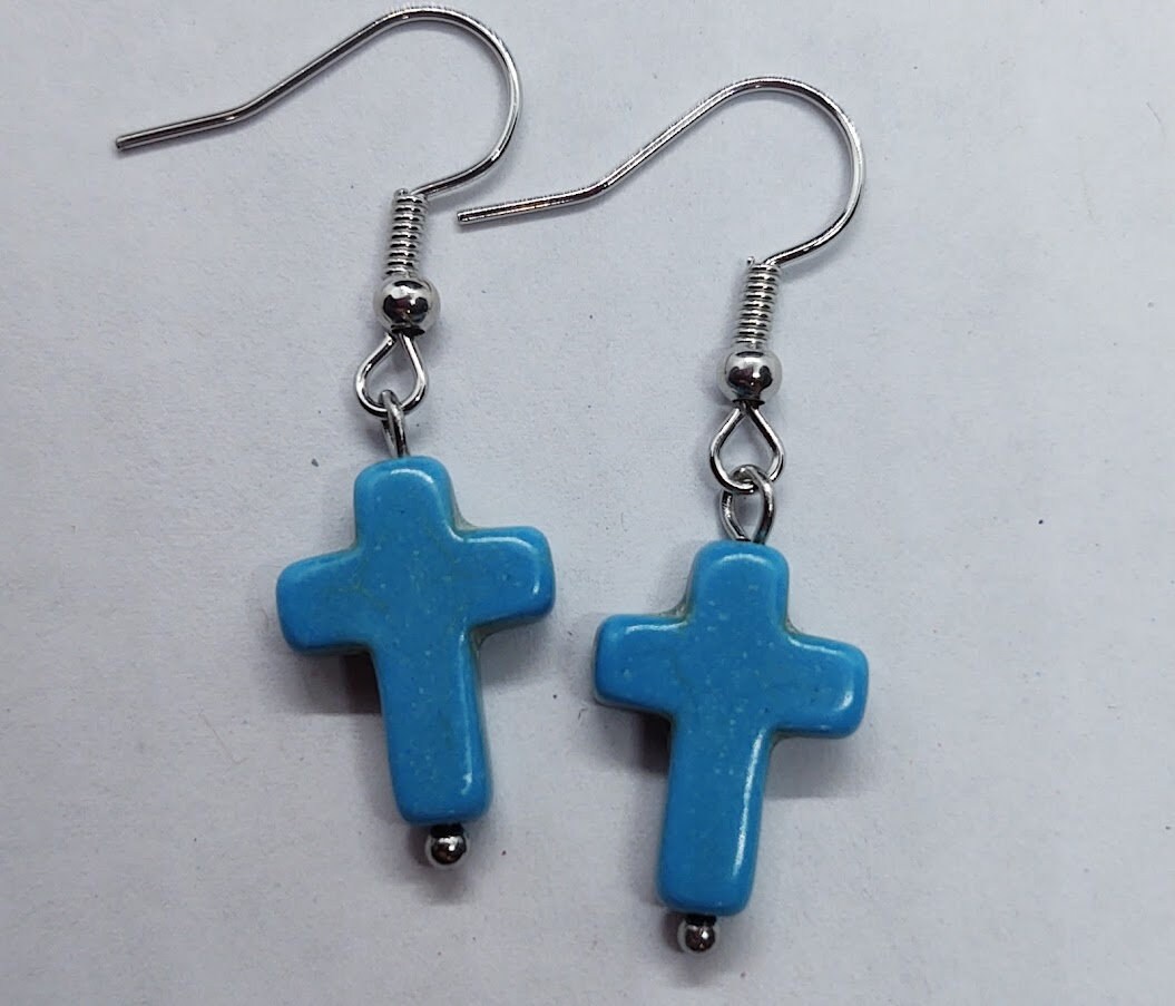 Reconstituted stone cross dangle earrings in turquoise blue or white.