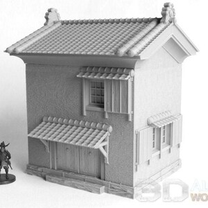 May include: A gray, unpainted, miniature model of a Japanese-style house with a tiled roof, shutters, and a small awning. The house has a simple, rectangular design with a single story.