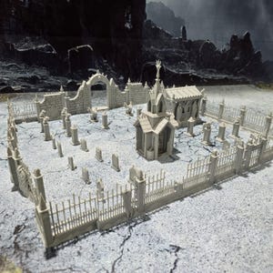 May include: A miniature gray cemetery scene with a chapel, tombstones, and a wrought iron fence. The scene includes an arched gate and several small, detailed gravestones. The background features a dark, ominous landscape.