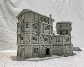 May include: A gray, multi-level, 3D printed building model with a gabled roof, multiple windows, and a door. The building has a rustic, medieval style.