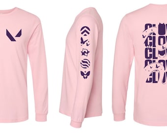 May include: Pink long-sleeve t-shirt with a purple Valorant logo on the front, a purple Valorant agent icon on the left sleeve, and the word "CLove" repeated five times on the back.