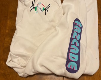 May include: White sweatpants with a purple, pink, and blue "FADE" graphic on the right leg and a green, pink, and white spider graphic on the left leg.