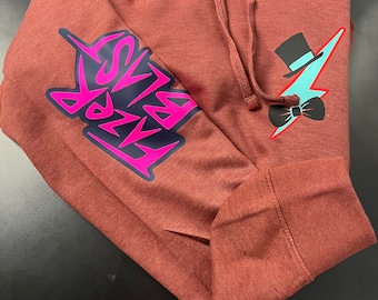 May include: A maroon hoodie with a pink and black graphic on the left sleeve that says "FADE" and a blue lightning bolt with a black top hat and bow tie on the right side.