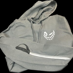 May include: A gray hooded sweatshirt with a white smiling face graphic on the front and a white knife graphic on the sleeve.