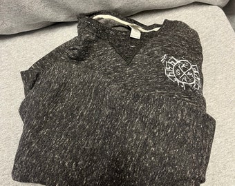 May include: A black and gray heather sweatshirt with a white graphic of a circle with a cross inside. The graphic has the text "The" and "Cross" on either side of the cross.