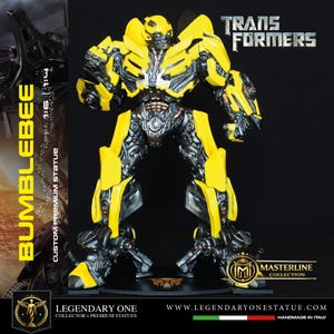 Könnte beinhalten: Eine Bumblebee Transformers Statue mit einem gelben und metallisch silbernen mechanischen Design. Die Figur steht auf einem schwarzen Sockel mit dem Text BUMBLEBEE, TRANSFORMERS und MASTERLINE COLLECTION. Der Maßstab ist mit 1:6 | 1:4 angegeben.