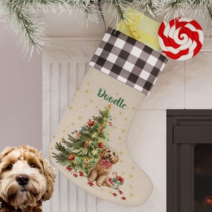 May include: A Christmas stocking with a black and white checkered cuff, personalized with the name "Doodle" in green script. The stocking features a Christmas tree and a dog illustration. A red and white swirled lollipop and a wrapped gift are visible.