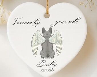 May include: White heart-shaped ceramic ornament with a gray French Bulldog illustration wearing angel wings. The text "Forever by your side" and the name "Bailey" are printed on the ornament, along with the dates 2010-2023. A brown string is attached for hanging.