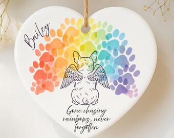 May include: Heart-shaped ceramic ornament with a rainbow paw print design. Features a French bulldog illustration with angel wings, the name "Bailey", and the text "Gone chasing rainbows, never forgotten."