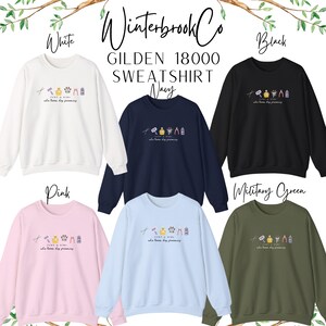 May include: A selection of Gildan 18000 sweatshirts in white, navy, black, pink, light blue, and military green. Each sweatshirt displays a small graphic and the text "JUST A GIRL who loves dog grooming."