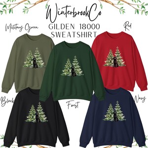 May include: A selection of sweatshirts in military green, forest green, red, black, and navy blue. Each sweatshirt displays a graphic of a black dog and two Christmas trees. The text "Winterbrook Co" and "GILDEN 18000 SWEATSHIRT" are at the top.