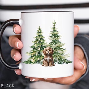 May include: White ceramic mug with a black handle and rim. The mug features a watercolor illustration of two green Christmas trees and a brown puppy. The word "BLACK" is printed at the bottom.