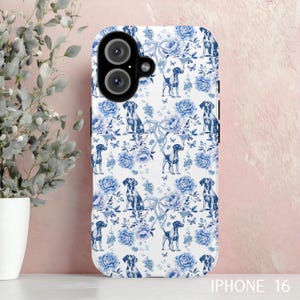 May include: A white iPhone 16 case featuring a blue floral and dog pattern. The design includes blue flowers, butterflies, and dog illustrations. The case has a camera cutout and the text "IPHONE 16" at the bottom.