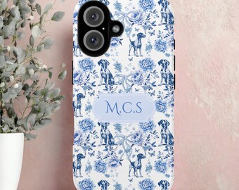 May include: White phone case with a blue floral and dog pattern. The case features a light blue oval with the initials "M.C.S." printed on it. The design includes butterflies and bows.