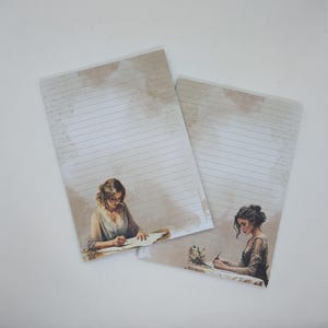 Könnte beinhalten: Zwei Blätter liniertes Briefpapier mit Vintage-Design. Jedes Blatt zeigt eine Illustration einer schreibenden Frau mit einem weichen, sepiafarbenen Hintergrund. Das Papier hat ein gealtertes Aussehen und erinnert an eine klassische, romantische Ästhetik.