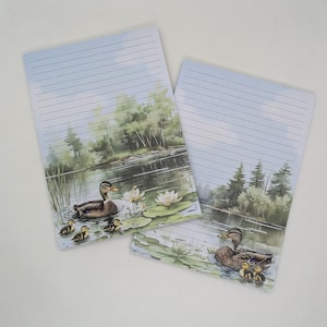 Könnte beinhalten: Eine weiße Keramik-Tasse mit schwarzem Henkel und dem Text "But First, Coffee" in fetter, schwarzer Schrift. Die Tasse steht vor einem neutralen Hintergrund, der ihr schlichtes Design hervorhebt.