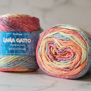 Op de afbeelding: Twee bollen Lana Gatto Smoothie garen in een meerkleurig ombre-patroon. Het garen is een mix van katoen en acryl en is gemaakt in Italië. Het label vermeldt "fashion Lana Gatto Smoothie Made in Italy".