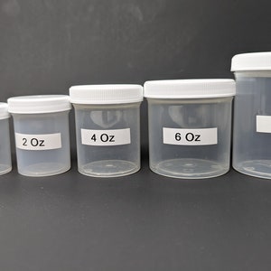 May include: A set of six clear plastic jars with white lids. The jars are labeled with their volume in ounces: 0.5 oz, 1 oz, 2 oz, 4 oz, 6 oz, and 8 oz.