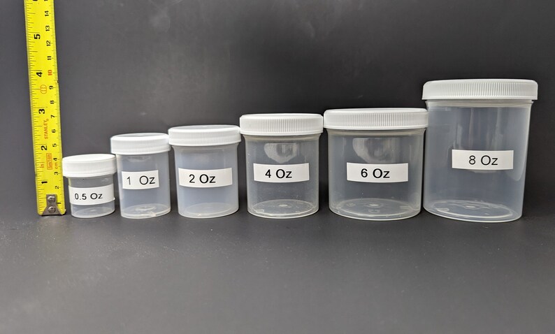 May include: Set of six clear plastic jars with white lids. The jars are labeled with their size in ounces: 0.5 oz, 1 oz, 2 oz, 4 oz, 6 oz, and 8 oz.