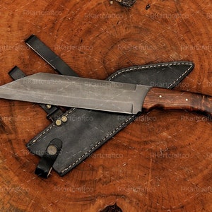 May include: A large, fixed blade knife with a brown wooden handle and a black leather sheath. The blade is made of steel and has a sharp point.