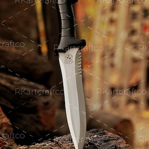 May include: A knife with a black handle and a silver blade. The blade has a serrated edge and a round emblem with the words "Special Forces" on it.