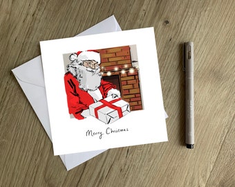 May include: A Christmas card featuring a cartoon illustration of Santa Claus holding a wrapped gift in front of a fireplace with a string of lights. The card reads "Merry Christmas".