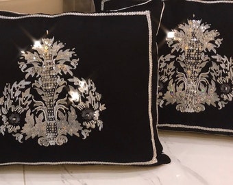 May include: Two black velvet throw pillows with silver sequin embroidery of a floral design.