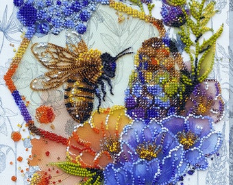 Puede incluir: Una obra de arte de cuentas que representa una abeja polinizando flores. La abeja es marrón y amarilla con alas transparentes. Las flores son azules, moradas y naranjas. El fondo es un lienzo blanco con un patrón floral azul claro.