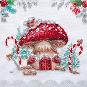 Op de afbeelding: Een rood en wit geperld paddenstoelenhuis met een rode deur en snoepstokken aan beide kanten. Het huis is omgeven door groen en blauw geperld gebladerte.