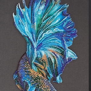 Könnte beinhalten: Ein Kunstwerk aus Perlen, das einen blauen und grünen Kampffisch darstellt. Der Fisch ist mit ausgebreiteten Flossen dargestellt, was ein wunderschönes und komplexes Design ergibt.
